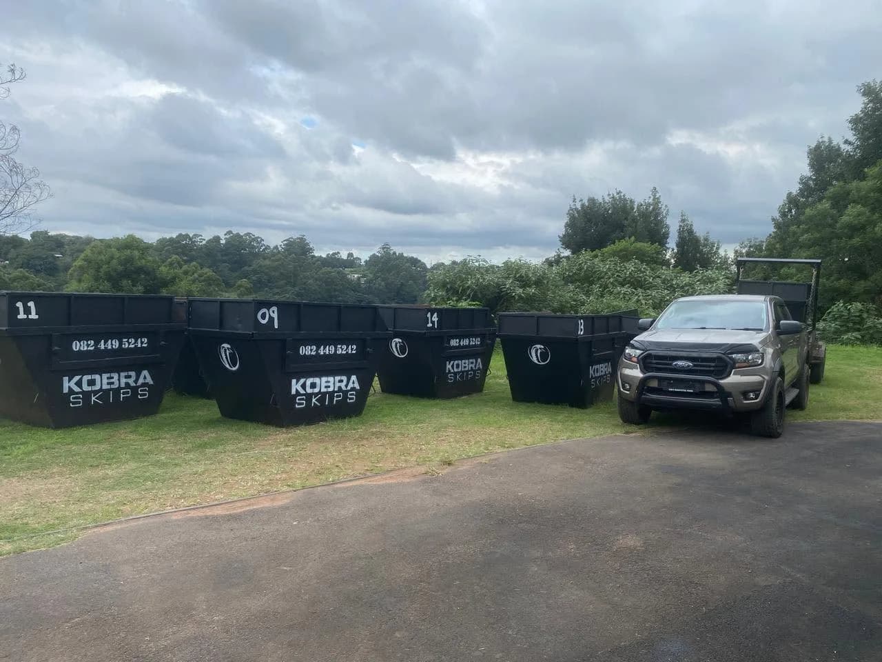 Three Kobra Skips lined up on a lawn next to the Ford Ranger — the full fleet ready for the Upper Highway.