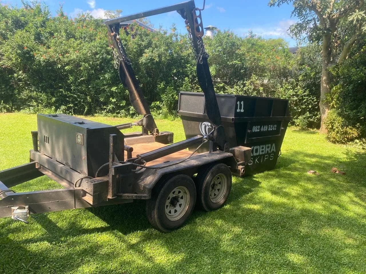 Empty Kobra Skip freshly delivered to a green lawn, ready to be filled.