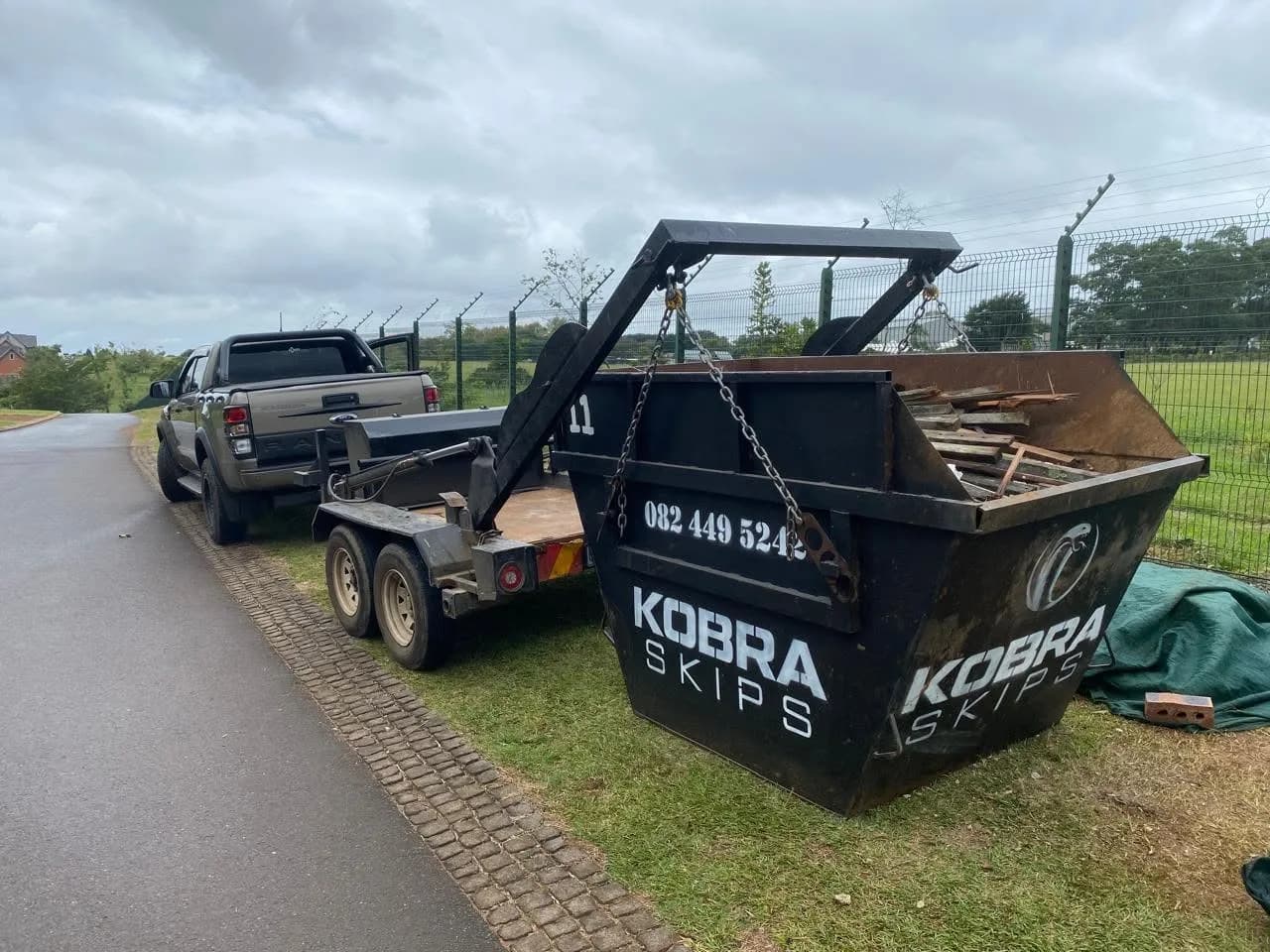 Kobra Skip loaded with building rubble, ready for collection from a roadside drop point in Pinetown.