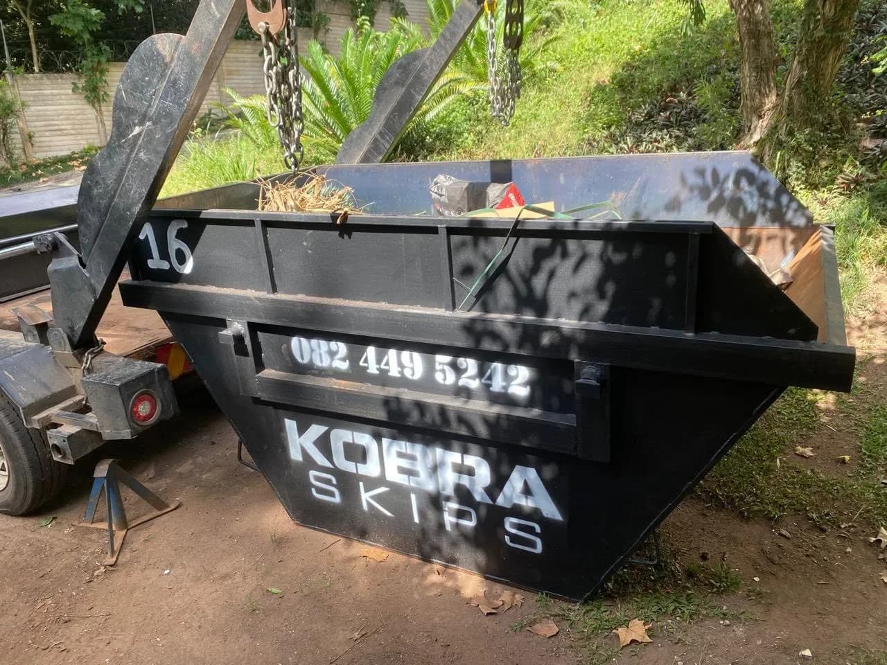 Kobra Skip number 16 suspended on the hoist, being loaded at a job in Pinetown.